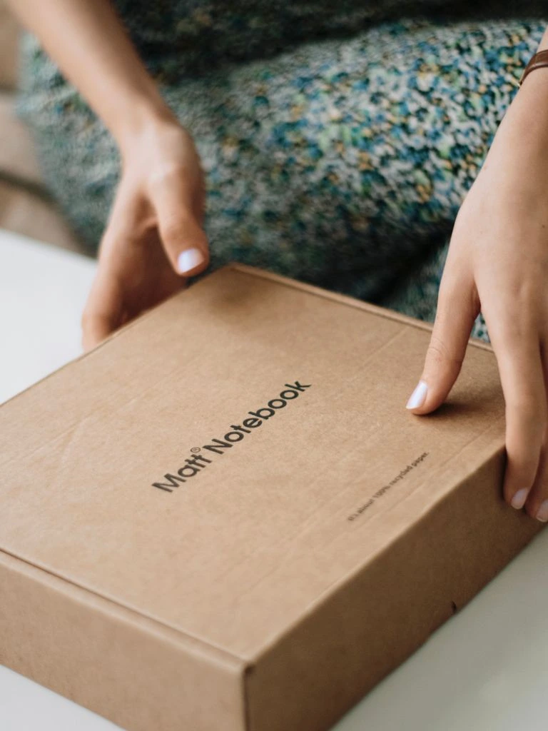 Subscription box unboxing scene with a support analytics dashboard visible on a laptop in the background